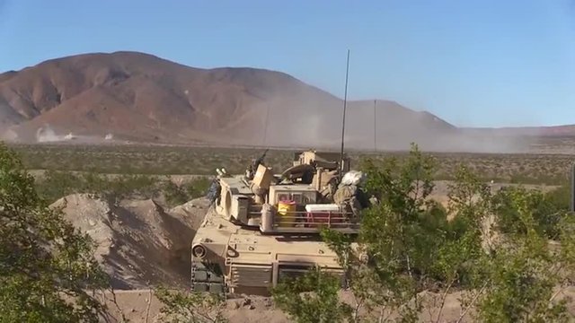 U.S. army tanks fire in the desert.