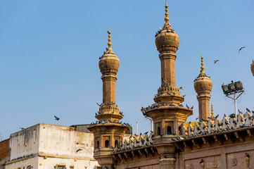 Fototapeta na wymiar Thin minarets of a mosque with pigeons sitting