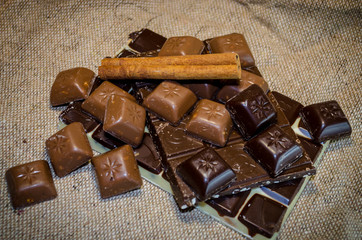chocolate bar and cinnamon sticks on a sack background