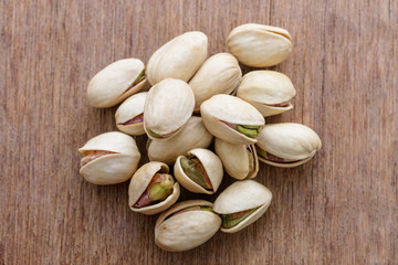 Pistachio nuts on wooden background texture