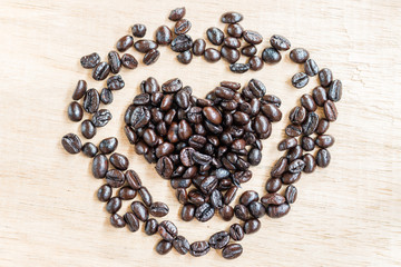 Coffee beans in heart shape  on wooden background