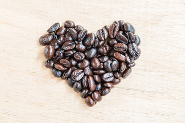Coffee beans in heart shape  on wooden background