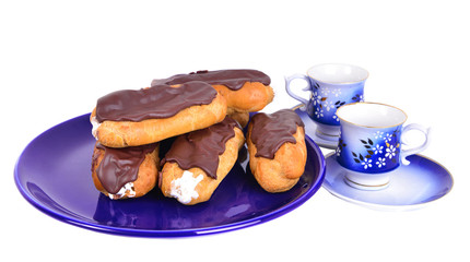  Eclairs on blue plate  with coffe cups