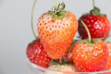 Ripe strawberries in saucer on wooden table on blurred backgroun