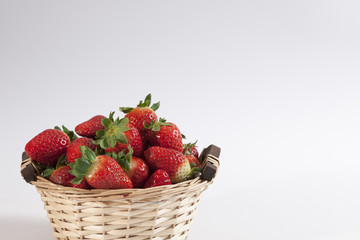 Wickerbasket with strawberries on white
