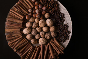 spices for baking, cinnamon sticks, star anise, cloves, nuts, coconut, coffee beans on a wooden background