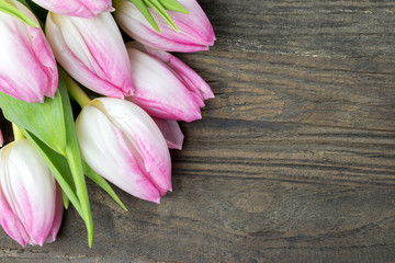 Pink tulips on wooden background.
Copy space.