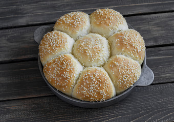 Homemade bread rolls in a vintage pan on wooden background