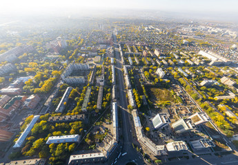 Aerial city view with crossroads, roads, houses, buildings and parks .