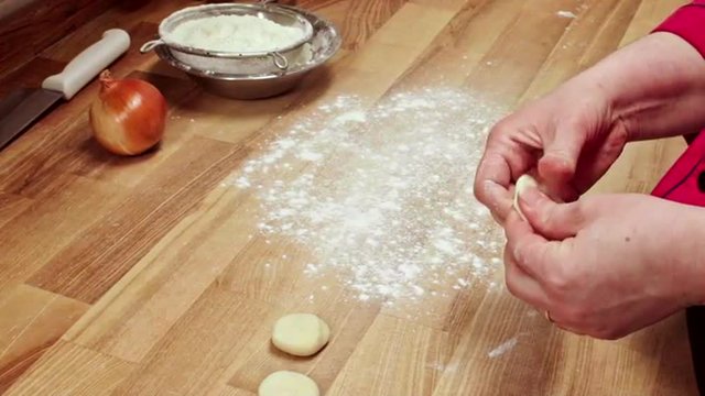 Chef making dumpling on wooden table. Slow motion