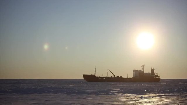 Time lapse fast motion of a Coast Guard icebreaker boat cutting it&rsquo;s way around as tuck commercial ship.