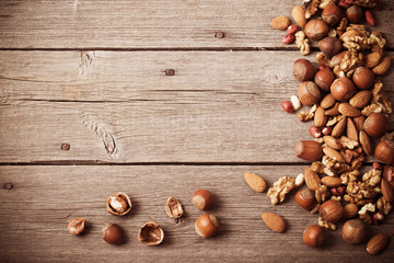 Mixed nuts on old wooden background