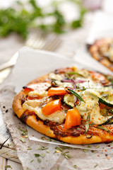 Vegetarian pizza with addition of pepper, zucchini, onion and herbs