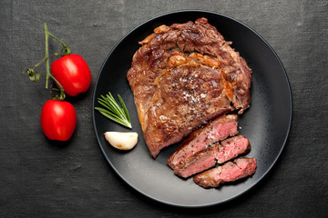 Medium rare grilled Steak Ribeye on dark background. Top view