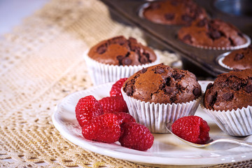 Chocolate muffins with red juicy raspberries