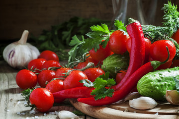 Red hot pepper with spring vegetables and herbs on a wooden cutt