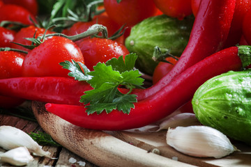 Red hot pepper with spring vegetables and herbs on a wooden cutt