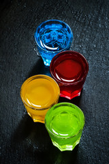Multi-colored cocktails on a dark background, top view