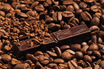 chocolate bar lying on instant coffee and coffee beans