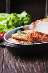 Baked meat with olive and tomato on the wooden table