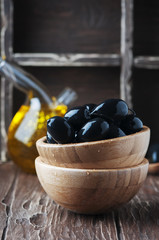 Black olive and olive oil on the wooden table