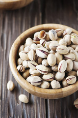Salt pistachio nuts in the wooden bowl