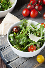 Healthy salad with rocket, tomato and parmesan cheese