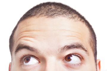 Naklejka premium Half face of a man looking to the corner, isolated on a white ba
