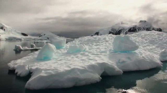A small iceberg floating in waters of Antarctica. Amazing beautiful views of Nature and landscape of snow, ice and white of Antarctic. Global Warming.