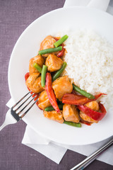 Spicy chicken with vegetables ( green beans and red pepper) and rice top view. Oriental food.