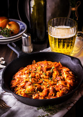 Stewed cabbage  in a vintage frying pan and a mug with beer.