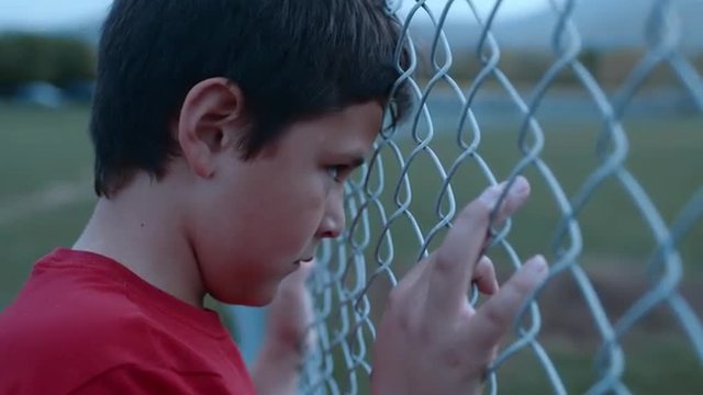 Sad boy looks presses face against face