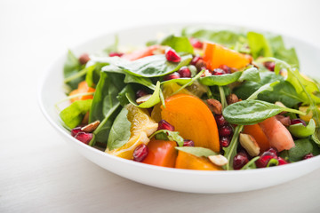 Fresh salad with fruits and greens on white background close up. Healthy food.