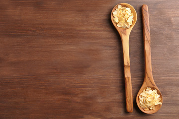 Two wooden spoons with almond flakes on the table, close-up