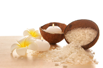 Spa concept of plumeria, coconut and candles with sea salt, isolated on white