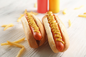 Hot dogs and fried potatoes on wooden background