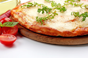 Pizza full of cheese on wooden board with vegetables isolated on white background, close up