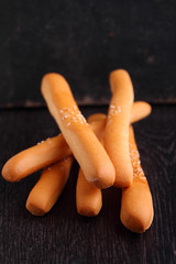 bread sticks in a glass on a black background