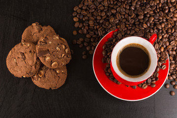 Good morning or Have a nice day message concept - bright red cup of frothy coffee with chocolate cookies, coffee beans
