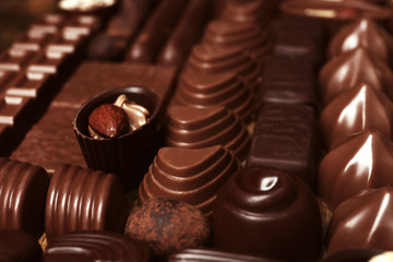 Assortment of delicious chocolate candies background, close up