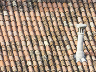 Old tiled roof of a House with a fireplace.
