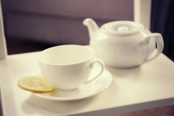 Tea cup and kettle on the table, closeup