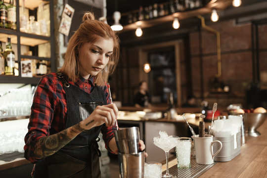 Woman Bartender Making An Alcohol Cocktail At The Bar