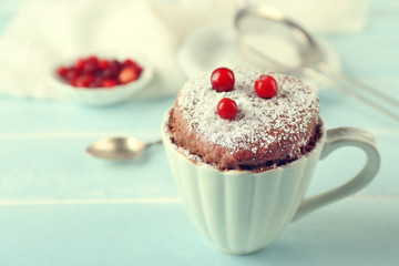 Powdered mug cake with cranberry on table