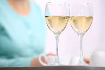Dinner with glasses of wine on light blurred background