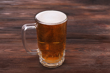 Glass of beer on wooden background