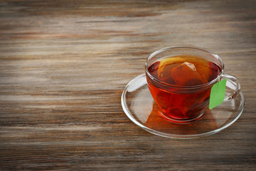 Cup of tea with tea bag on wooden table background