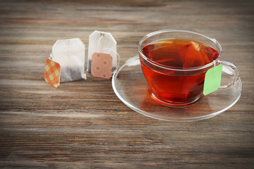 Cup of tea with tea bags on wooden table background