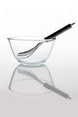 Glass transparent bowl with metal whisker inside on white background side view with reflection vertical composition