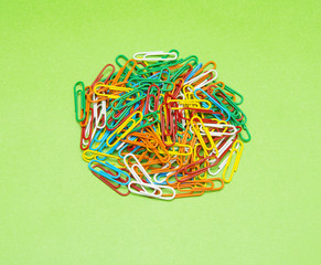 Colorful paper clip isolated on green background